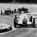 Grosser Preis von Italien in Monza, 09.09.1934. Der Sieger Rudolf Caracciola am Steuer des Mercedes-Benz Formel-Rennwagen W 25 mit der Startnummer 2, den er sich bei diesem Rennen mit Luigi Fagioli teilte. Im Hintergrund erkennt man einen Maserati Typ 6C.